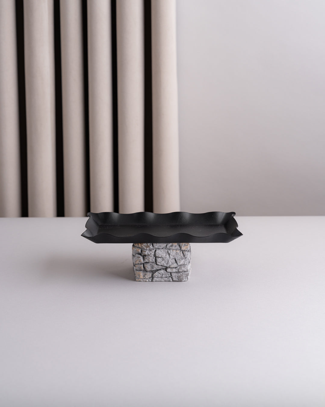 صحون تقديم سوداء مع قاعدة مرتفعة بتصميم حجري