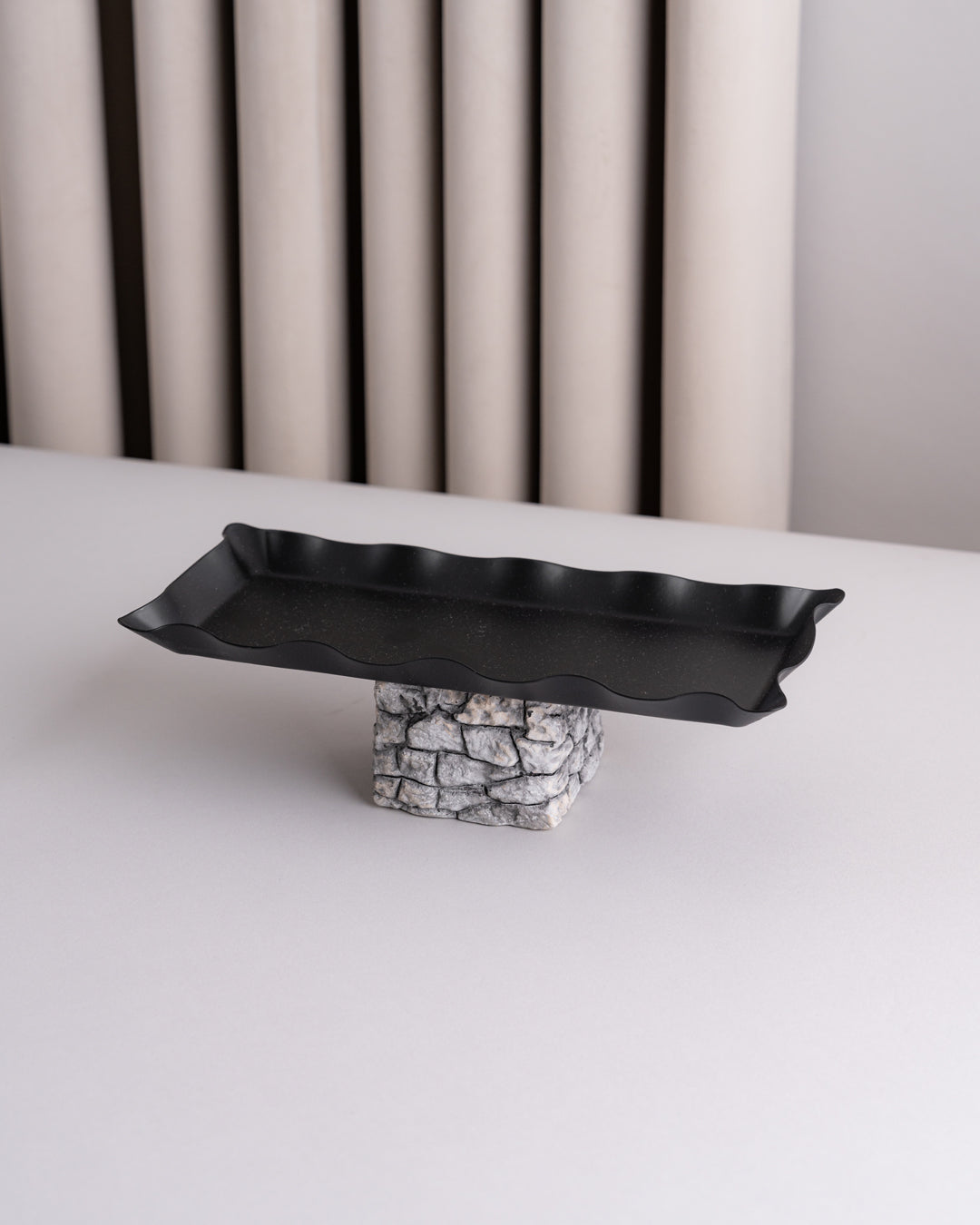 صحون تقديم سوداء مع قاعدة مرتفعة بتصميم حجري