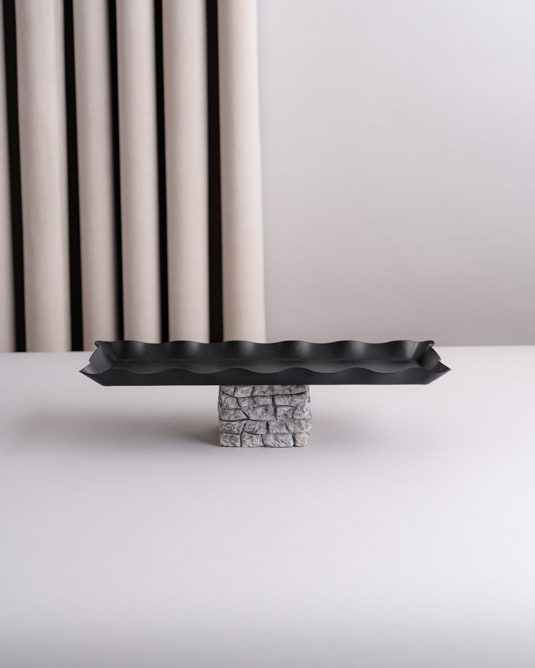 صحون تقديم سوداء مع قاعدة مرتفعة بتصميم حجري