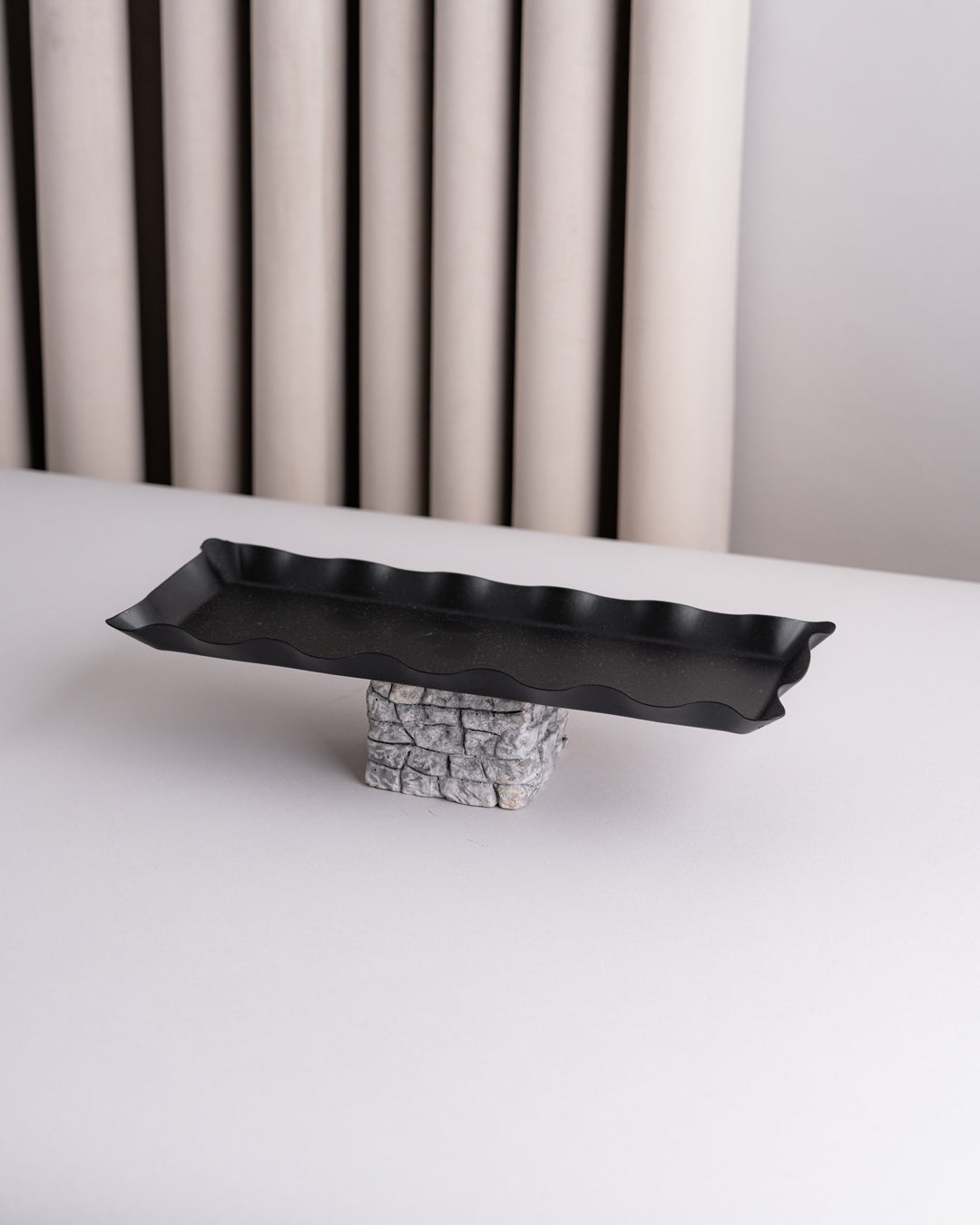صحون تقديم سوداء مع قاعدة مرتفعة بتصميم حجري